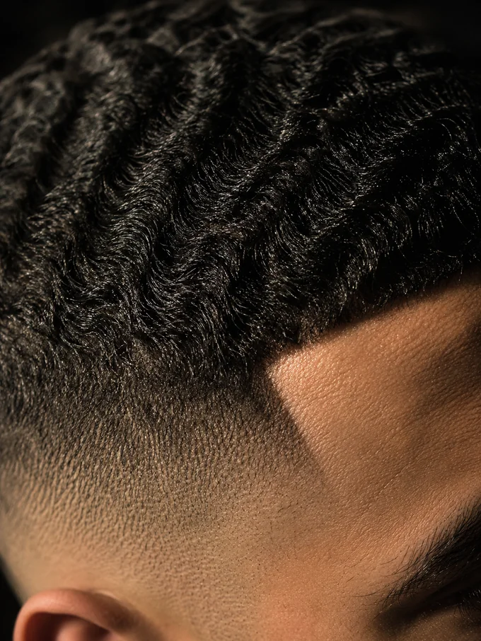 Close detail of the fade blend under wavy hair